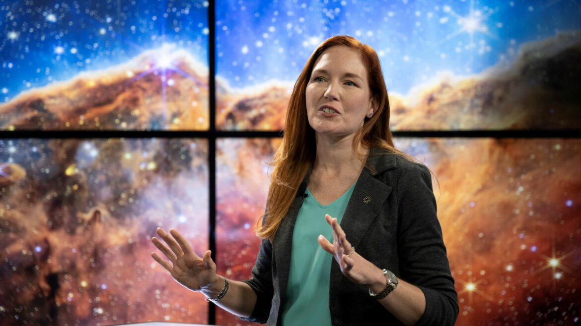 2022年7月12日星期二，在马里兰州格林贝尔特的美国宇航局戈达德太空飞行中心，美国宇航局詹姆斯·韦伯太空望远镜通信副项目科学家Amber Straughn在广播中讲述了位于艇座星云中名为NGC 3324的恒星形成区域的红外图像，该图像显示在韦伯望远镜发布的第一张全彩色图像的广播屏幕上。